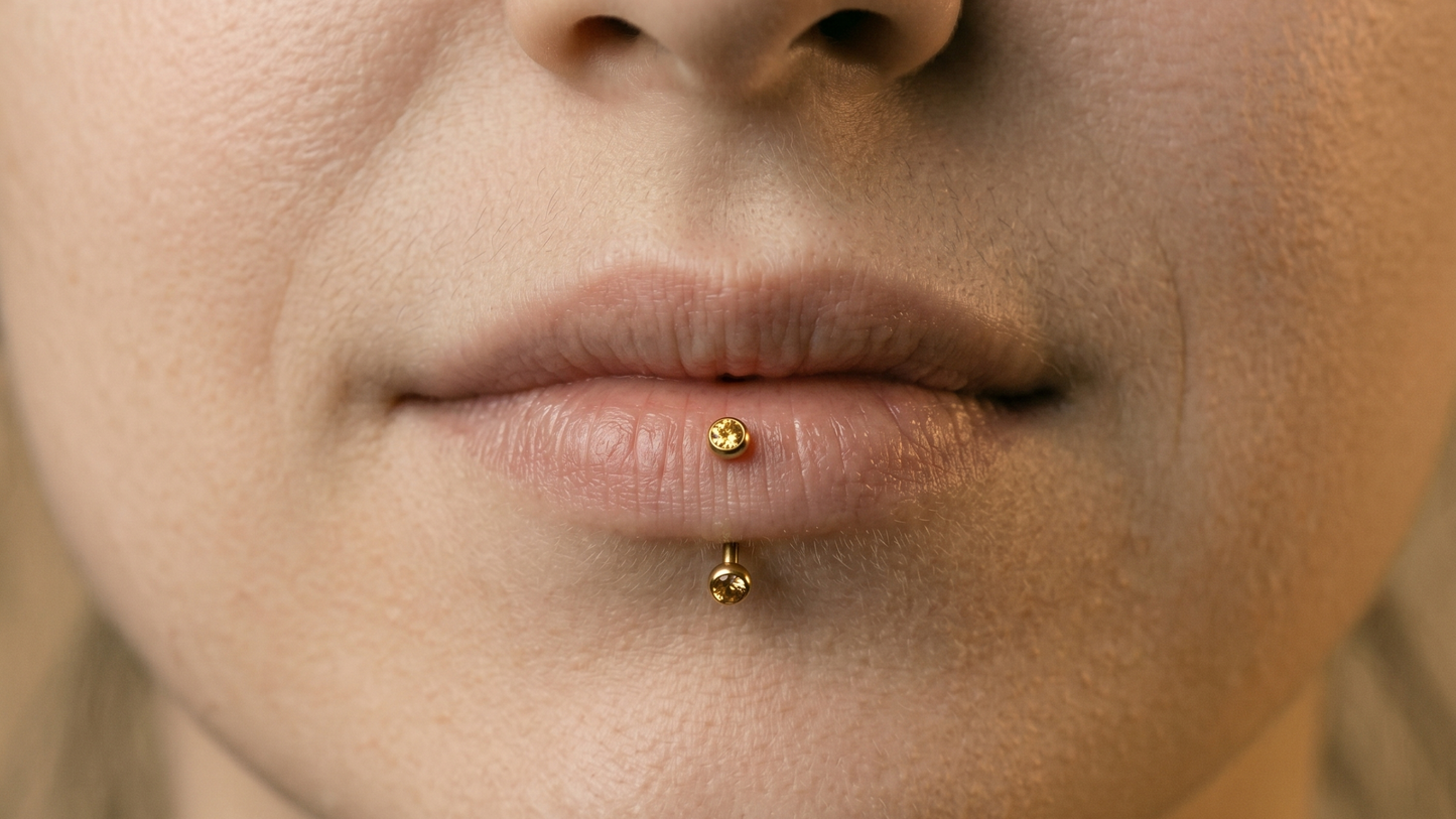 a curved barbell with one end visible on the lower lip surface and the other below the lip on the chin