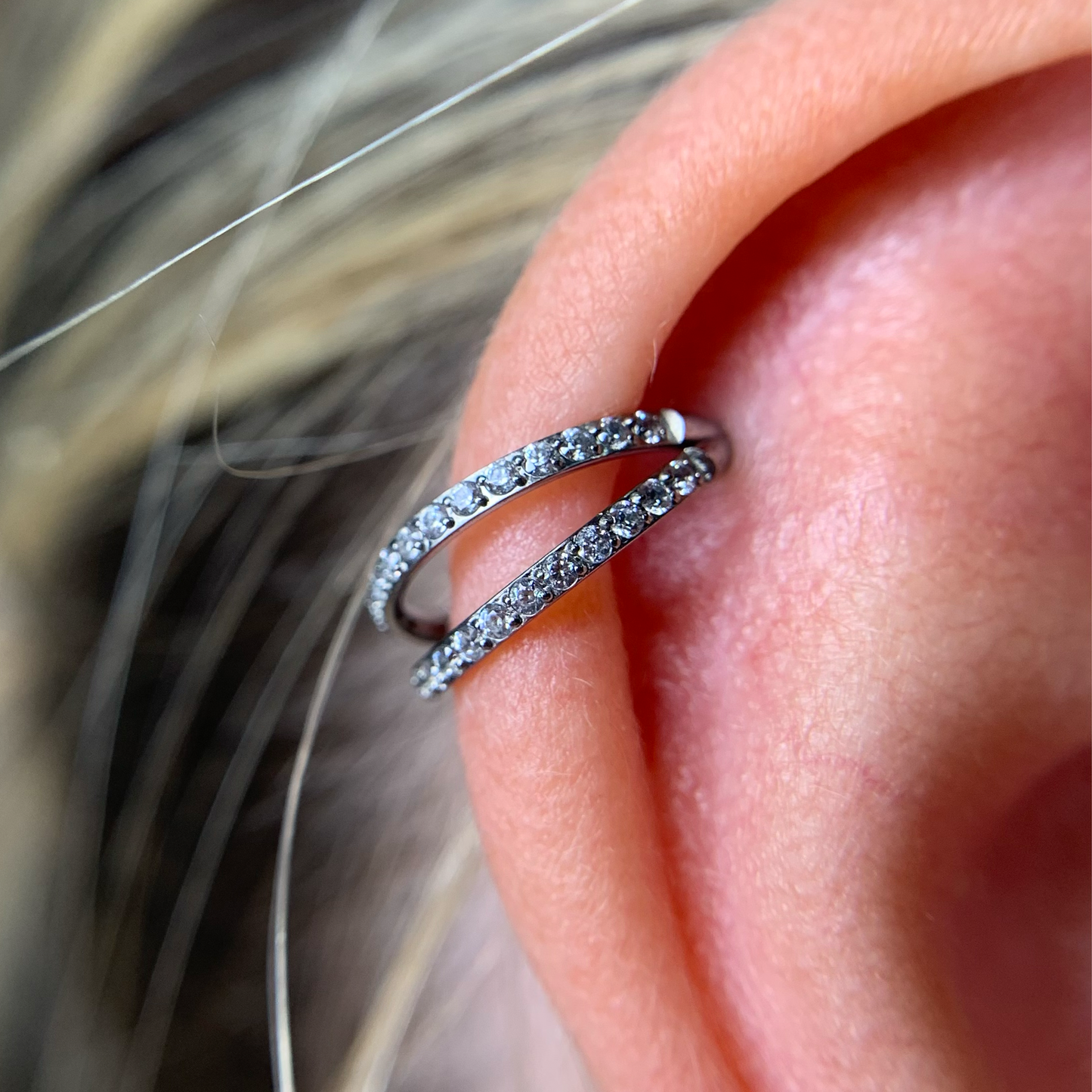 Argola dupla com zircónias aplicada no hélix da orelha – encaixe confortável e elegante