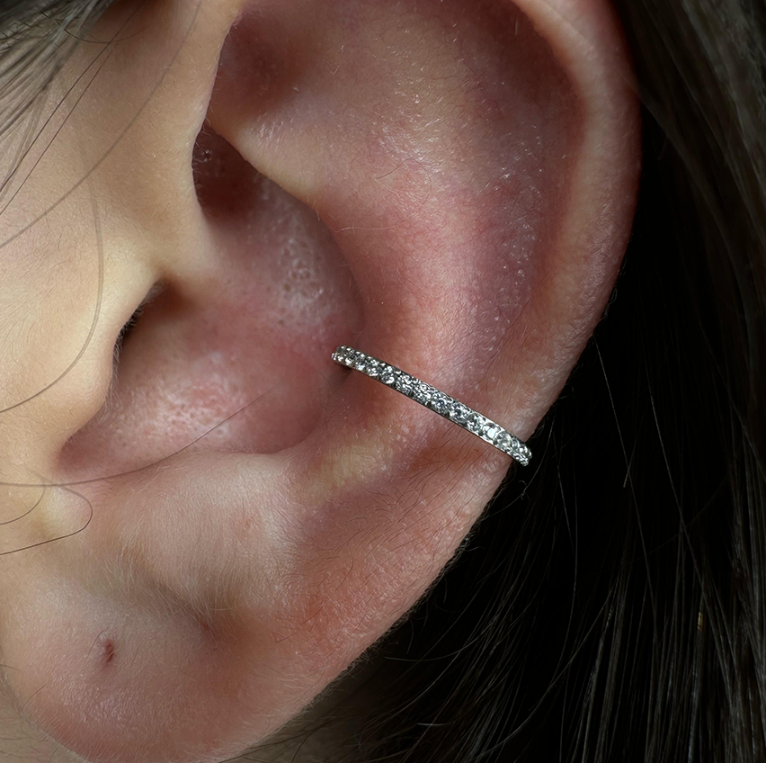 
                  
                    Argola com zircónias laterais aplicada na conch – encaixe confortável em titânio
                  
                