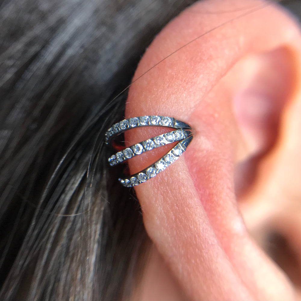 Triple ring with zirconias applied to the helix of the ear - three-ring effect with intense shine